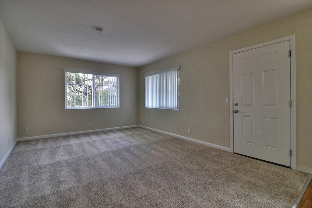 A room with a carpeted floor and a white door.
