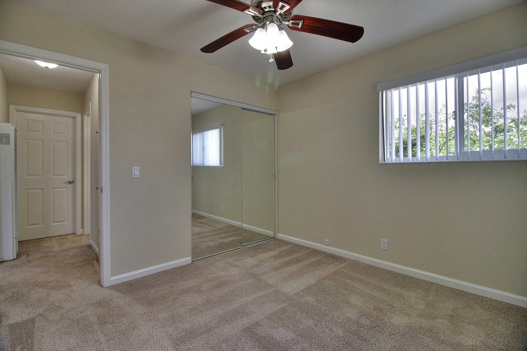 A room with a ceiling fan and a carpeted floor.