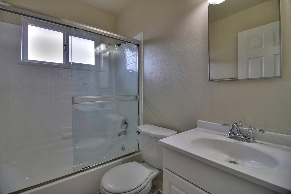 A white toilet sits next to a sink in a bathroom.