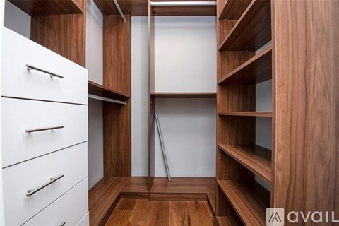 A wooden kitchen with white cabinets and a white door.