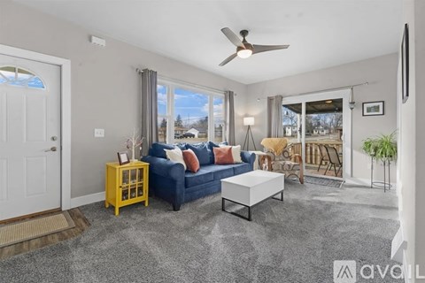 A living room with a blue couch and a yellow side table.