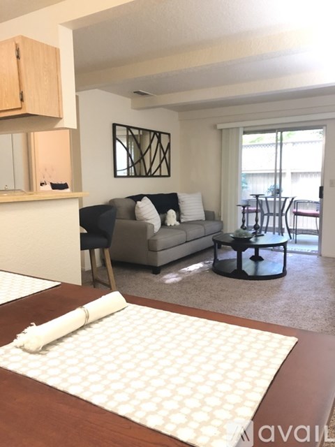A living room with a grey couch and a coffee table.
