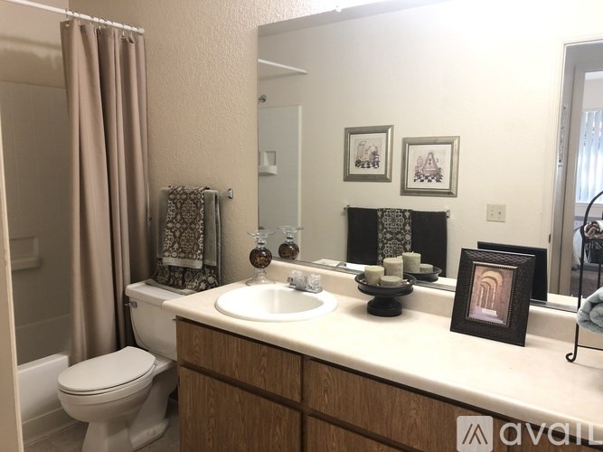 A bathroom with a toilet, sink, and a mirror.