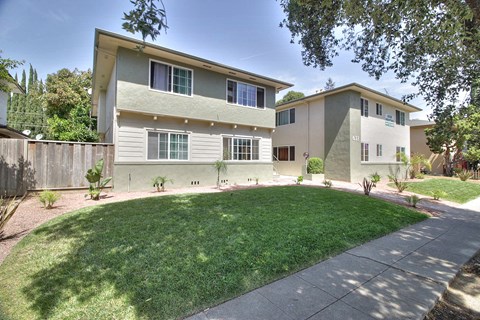 A two-story building with a green lawn in front.