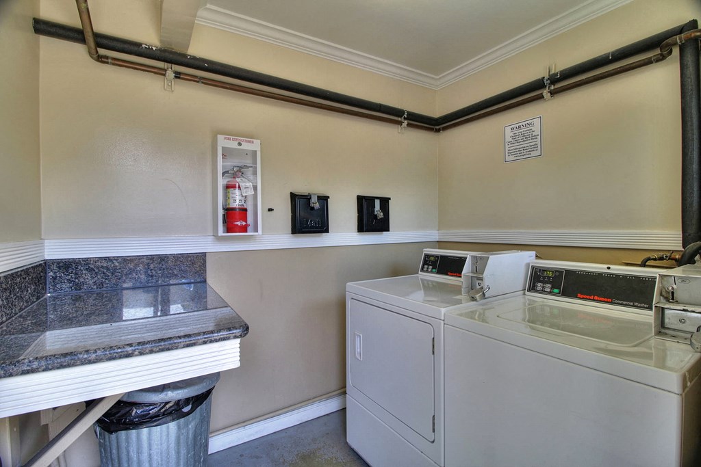 a laundry room with a washer and dryer and a counter with a sink