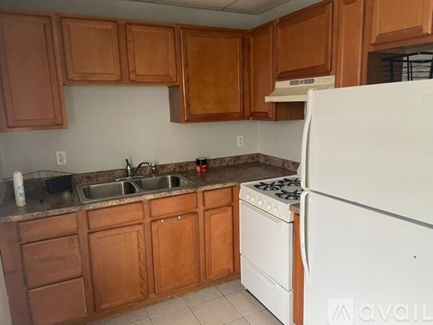 A kitchen with wooden cabinets and a white refrigerator.