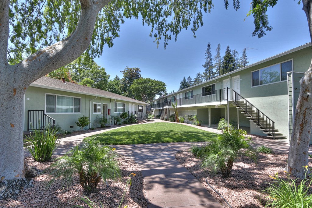 A sunny day at the apartment complex with greenery and trees.