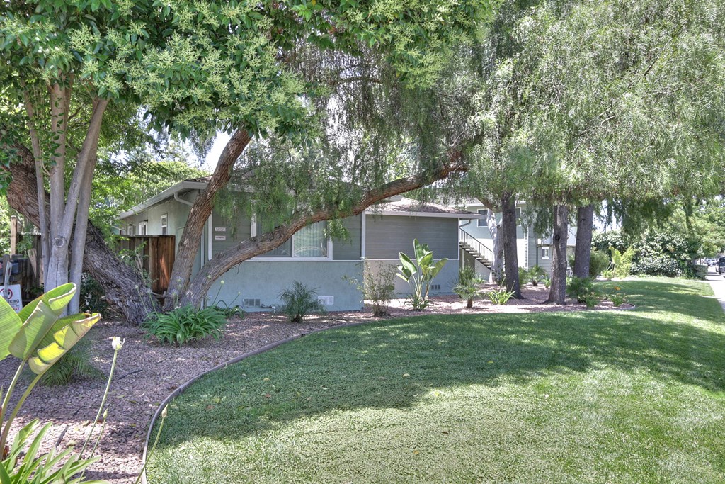 A building is surrounded by a green lawn and trees.