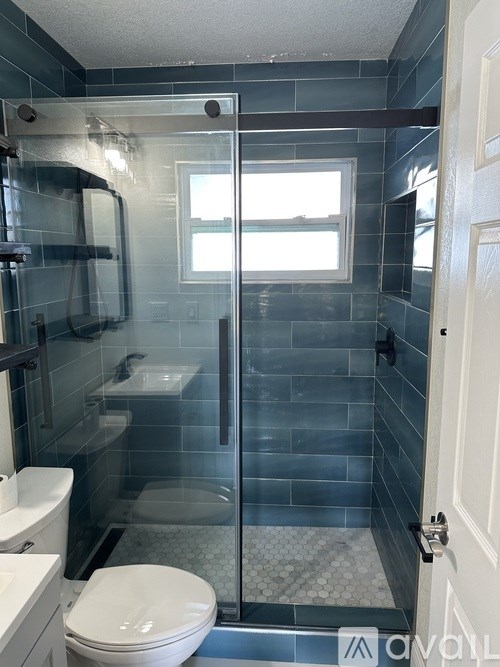 A bathroom with a toilet, sink, and shower.