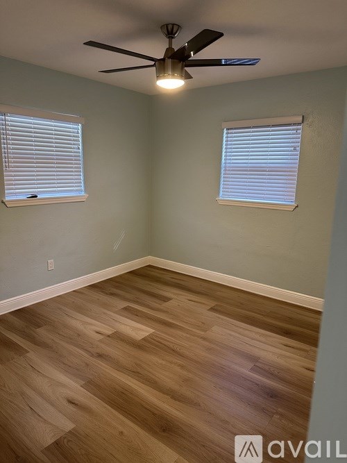 A room with wooden flooring and a ceiling fan.