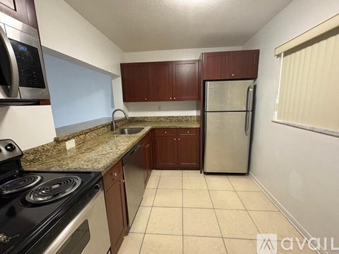 A kitchen with brown cabinets and a granite countertop.