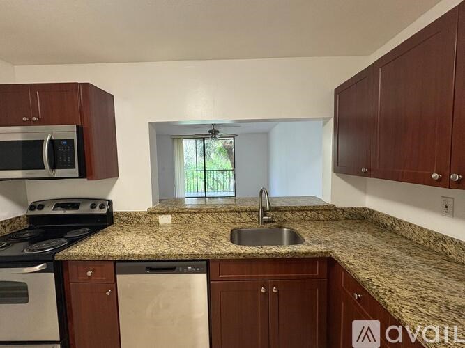 A kitchen with brown cabinets and granite countertops.