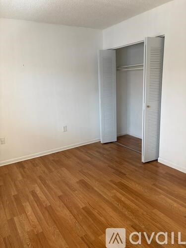 A room with wooden flooring and a white door.