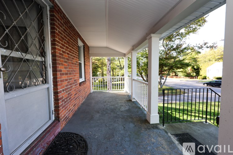 A porch with a white railing and a black gate.