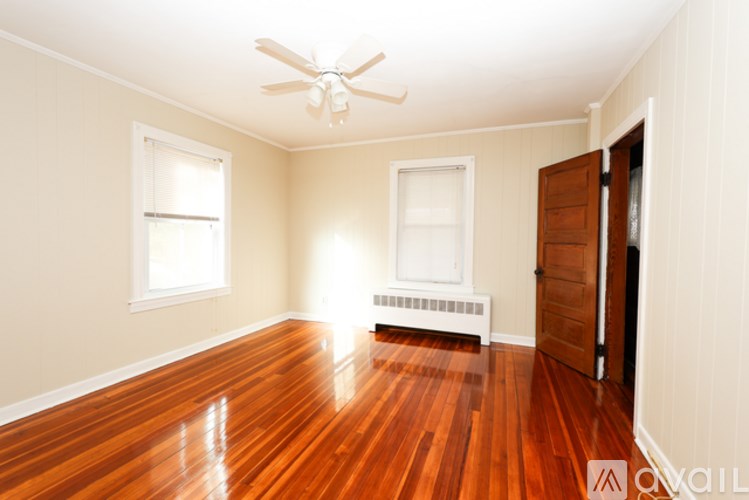 A room with wooden floors and a ceiling fan.