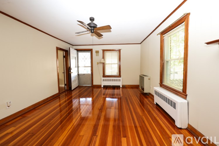 A room with wooden floors and a ceiling fan.