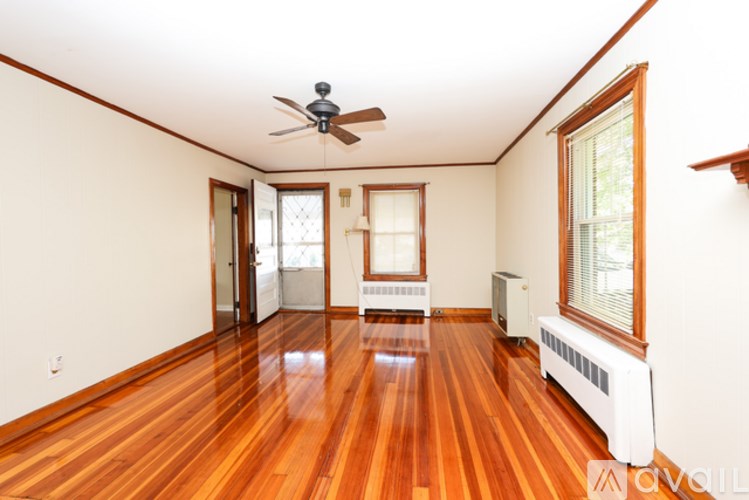 A room with wooden floors and a ceiling fan.