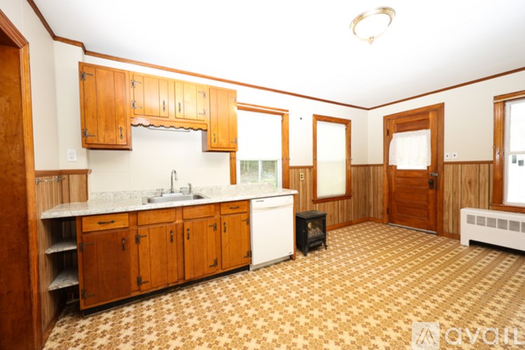 A kitchen with wooden cabinets and a patterned floor.