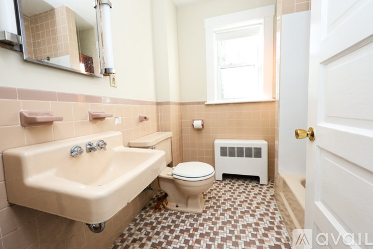 A bathroom with a sink, toilet, and a window.