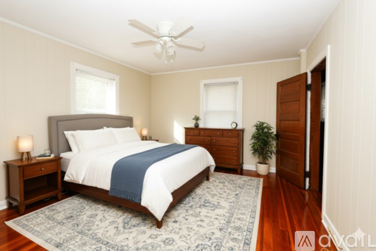 A bedroom with a bed, nightstands, and a ceiling fan.