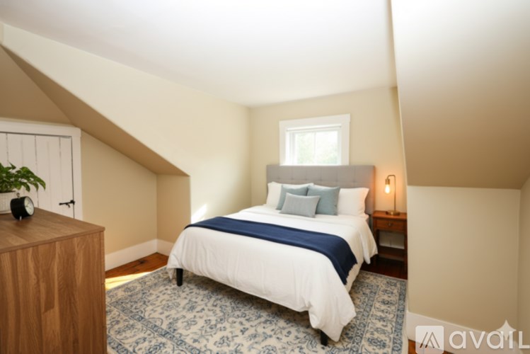 A bedroom with a bed, nightstand, and window.