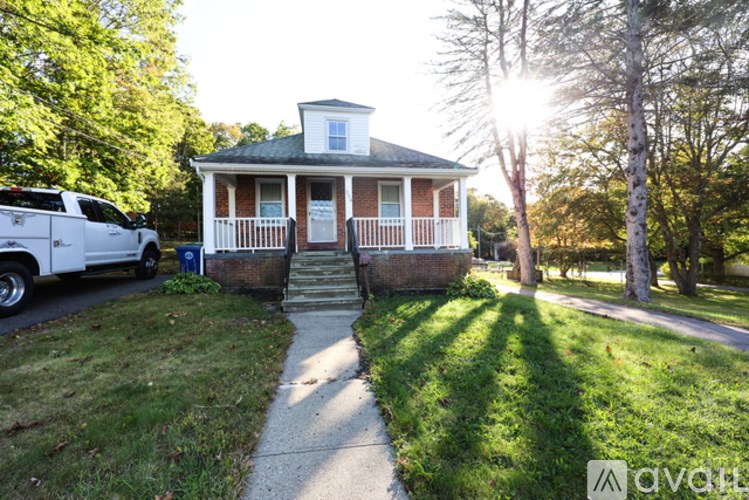 A house with a white picket fence and a car parked in front.