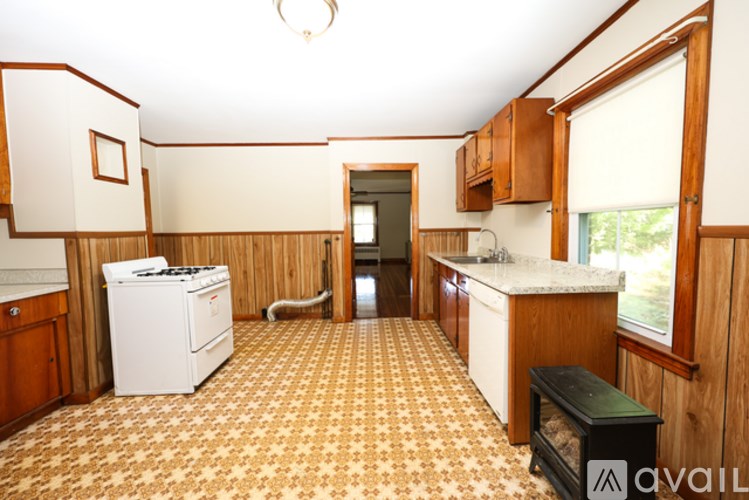A kitchen with a white dishwasher and a black stove top.