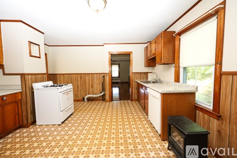A kitchen with a white dishwasher and a black stove top.