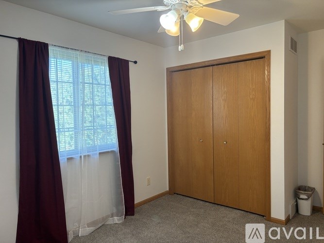 A room with a ceiling fan and a sliding door.