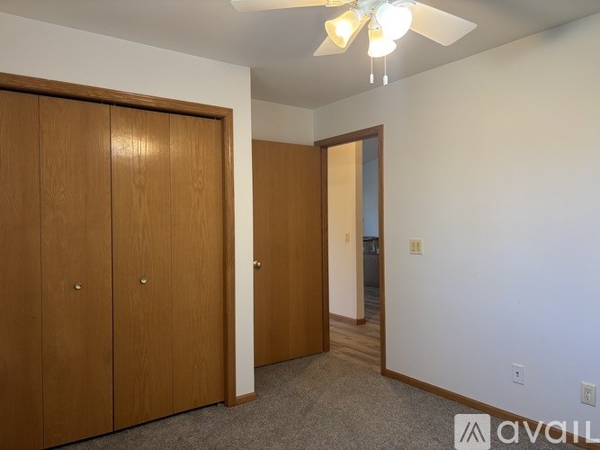 A room with two brown doors and a carpeted floor.