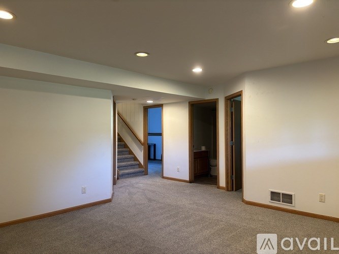 A spacious room with a staircase leading to a balcony.