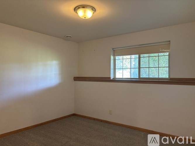 A room with a window and a light on the ceiling.