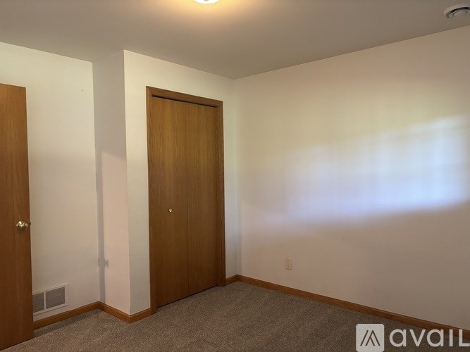 A room with two doors and a carpeted floor.