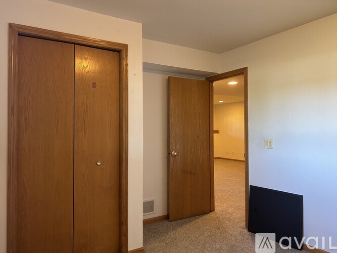 A room with two wooden doors and a carpeted floor.