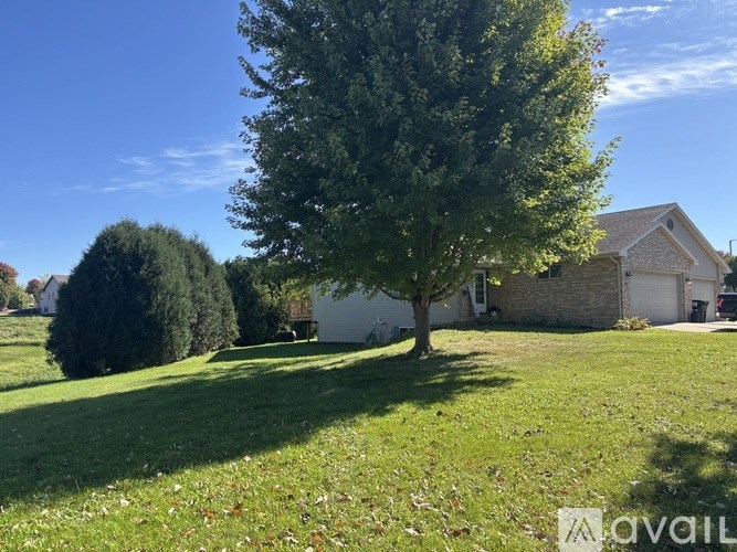 A house with a lawn and trees in front of it.