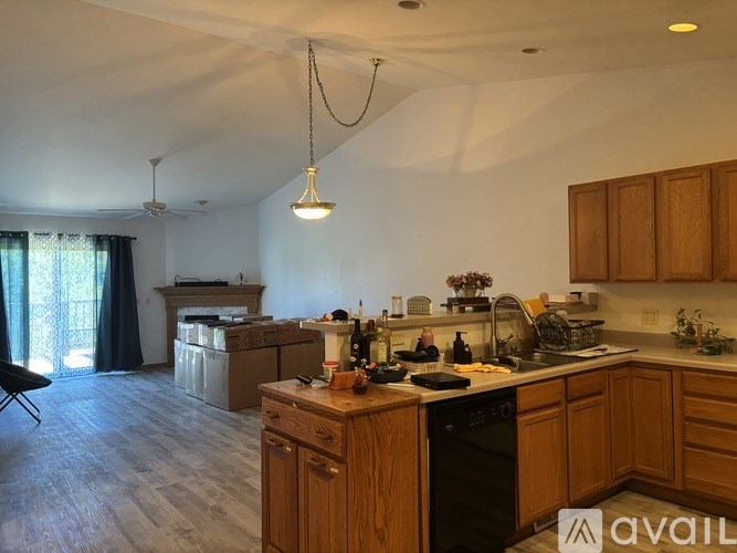 A kitchen with wooden cabinets and a black dishwasher.