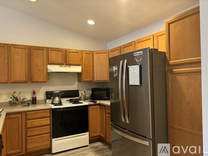 A kitchen with wooden cabinets and a fridge with a magnet on it.
