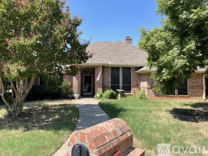 A house with a brick pathway leading to the front door.