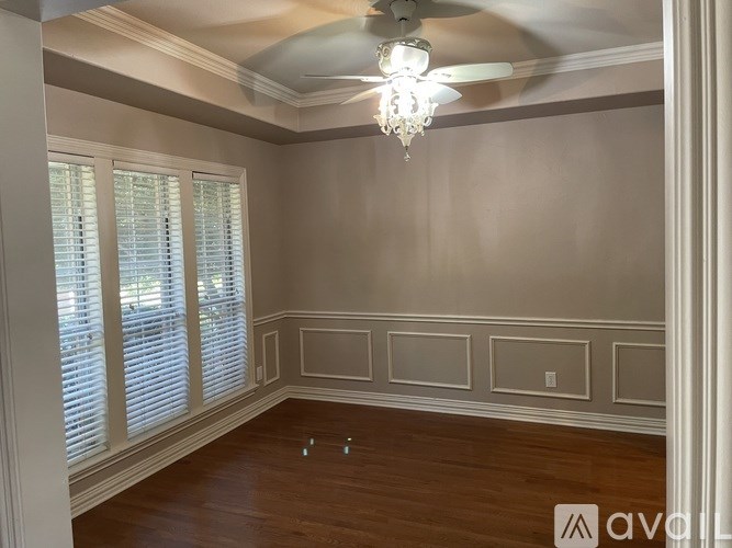 A room with wooden floors and a chandelier hanging from the ceiling.