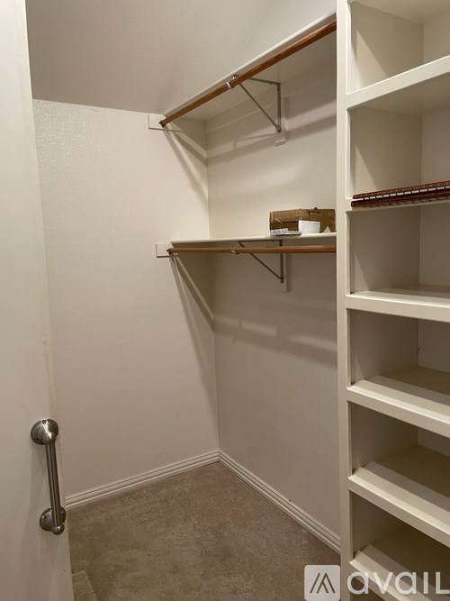 A white closet with shelves and a door handle.