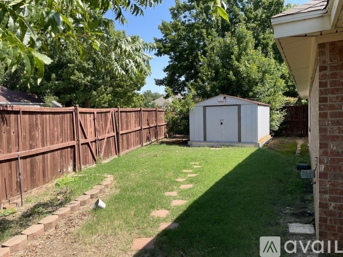 A backyard with a wooden fence and a shed.