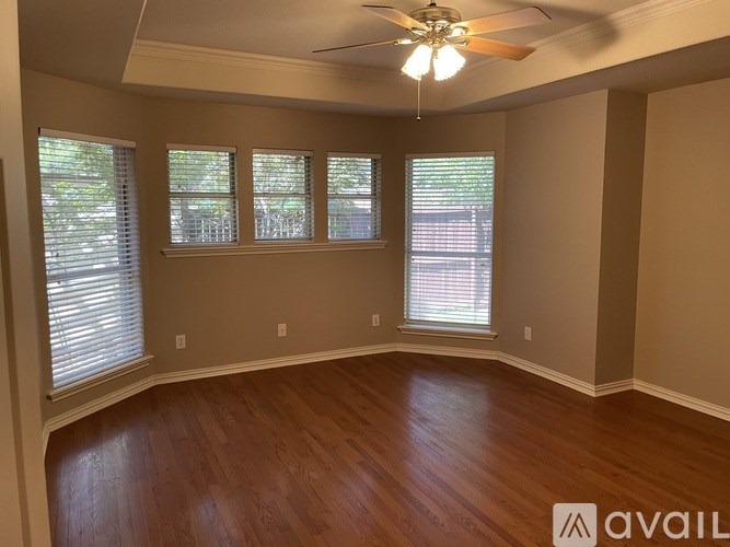 A room with wooden floors and a ceiling fan.