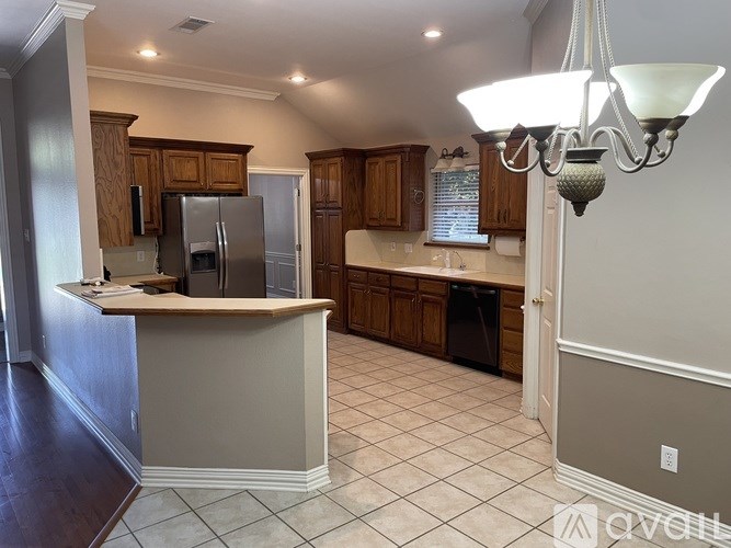 A kitchen with a refrigerator, cabinets, and a counter.