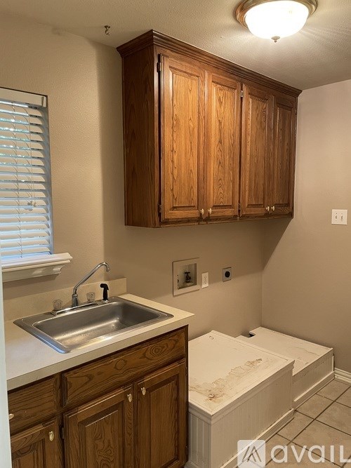 A kitchen with wooden cabinets and a white sink.