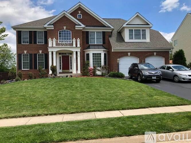 A two-story brick house with a red door and a garage.