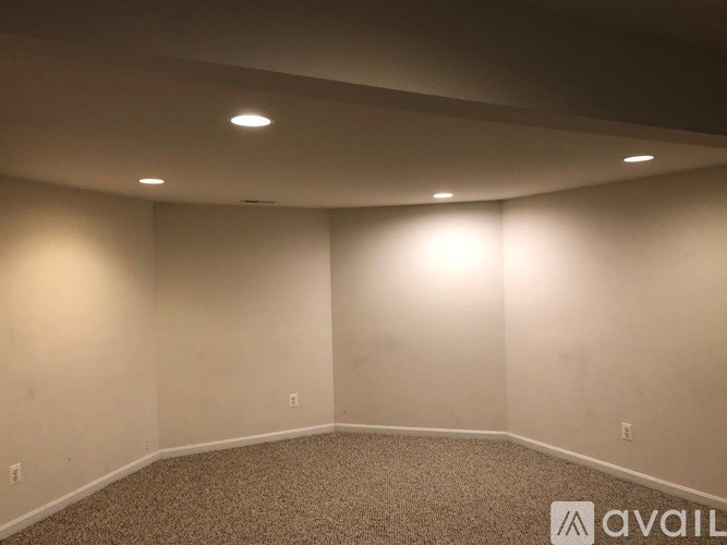 A room with carpeted floor and wall-mounted lights.