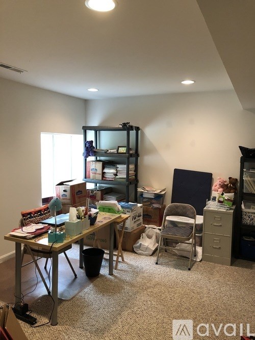A room with a table, chairs, and a bookshelf.