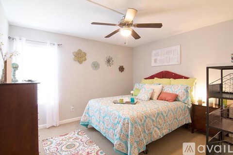 A bedroom with a bed, a ceiling fan, and a rug.