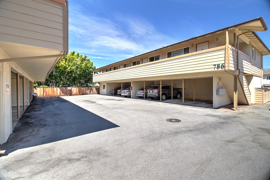 a parking garage with cars parked in front of a building