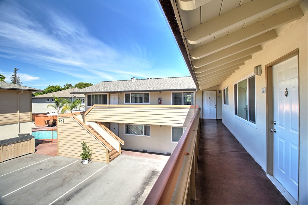a balcony with a white door and a house with a pool